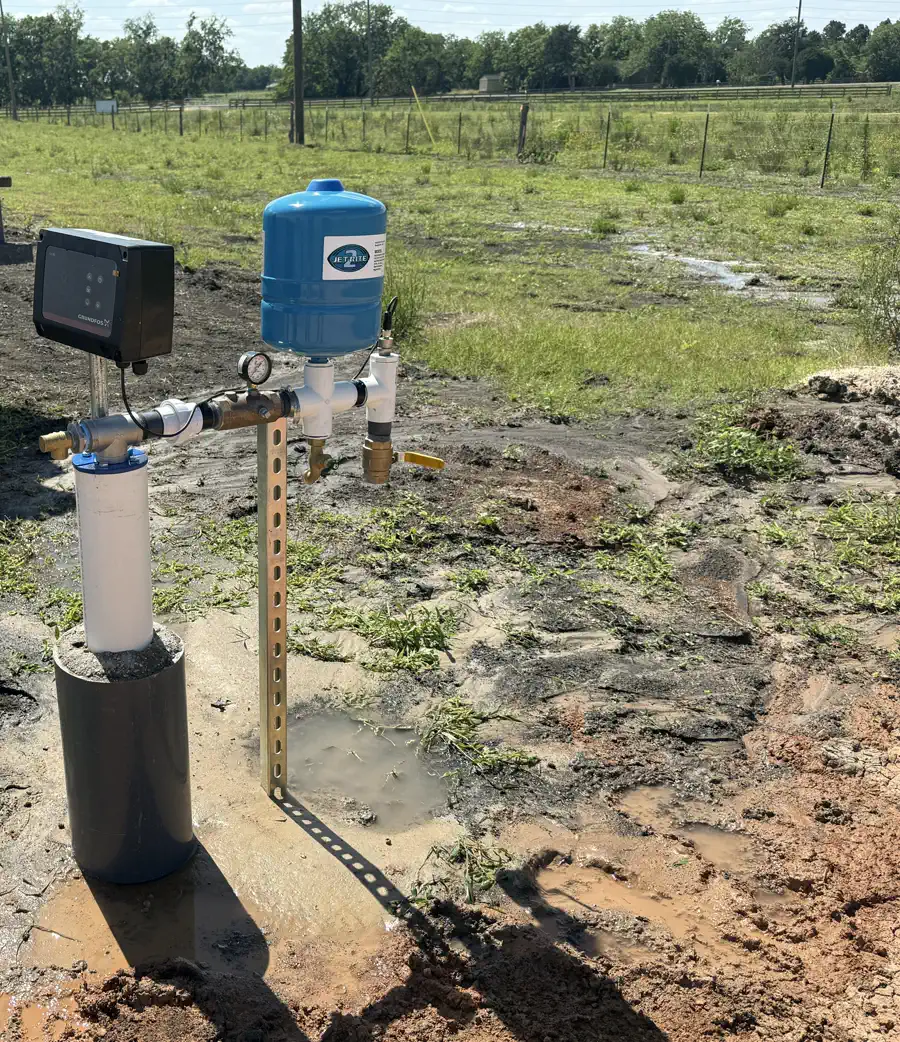A Grundfos SQE variable-speed system installed by Texas Southern Drilling — a compact bladder tank and control box on a concrete pad